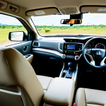 **

A comfortable and quiet interior of a Honda Ridgeline during a long road trip. The focus should be on the comfortable seats and the lack of noise inside the cabin. Show passengers relaxing and enjoying the ride.  Include elements that suggest Thailand, such as scenery visible through the windows.

**